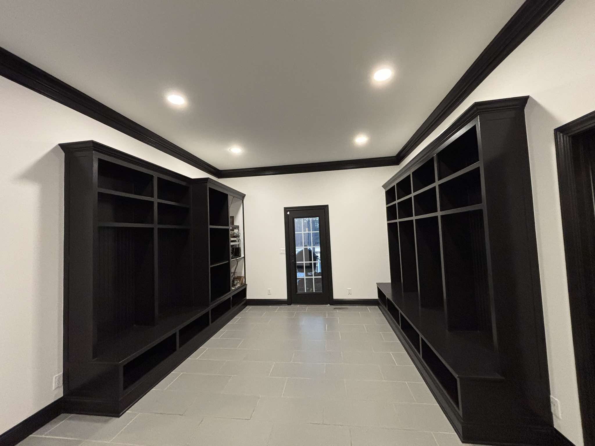 Finished room with opposing black built-ins, black trim, and bright white wall contrast