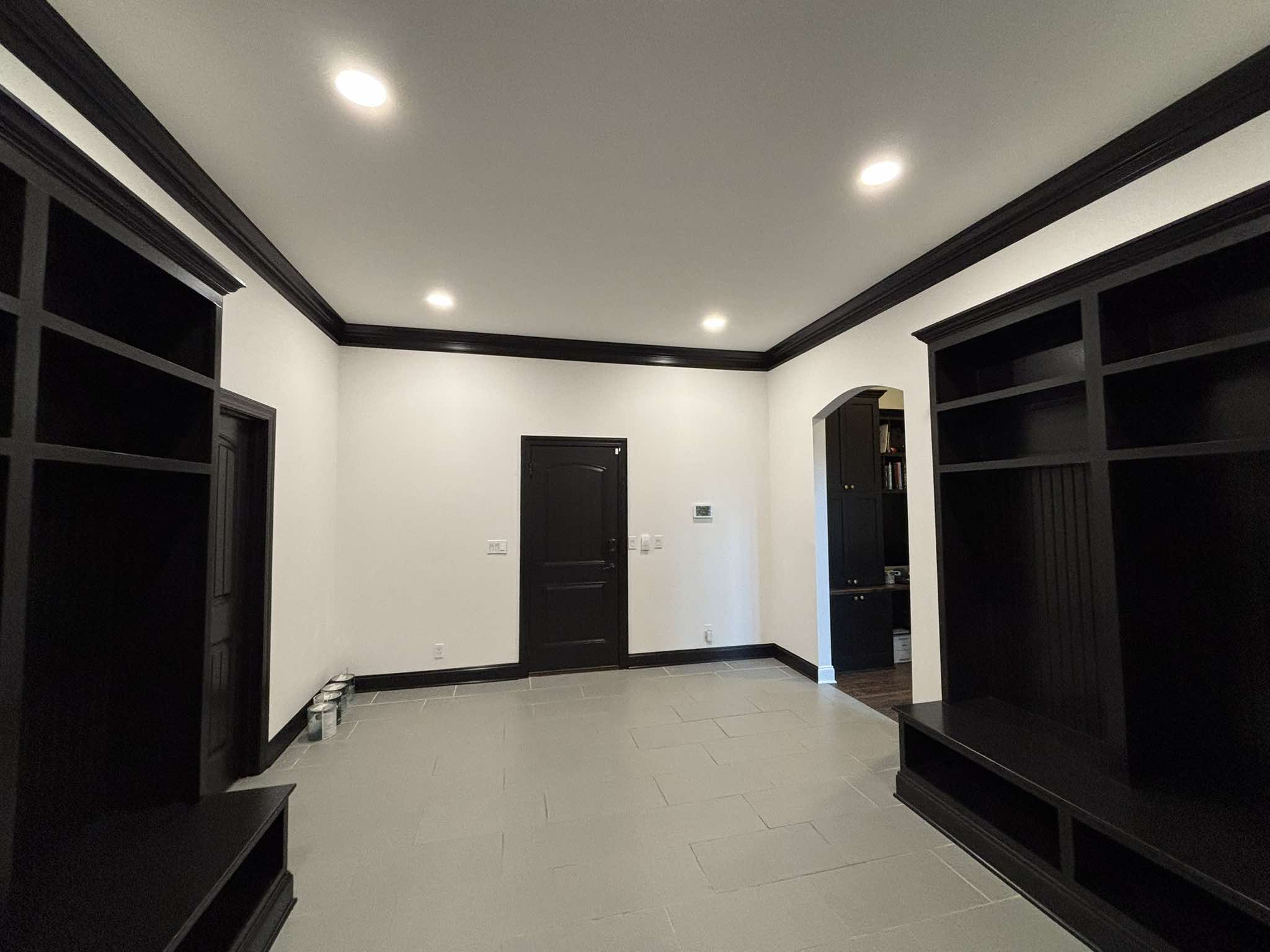 Completed black built-ins framing the room with coordinated doorway, crown molding, and baseboards