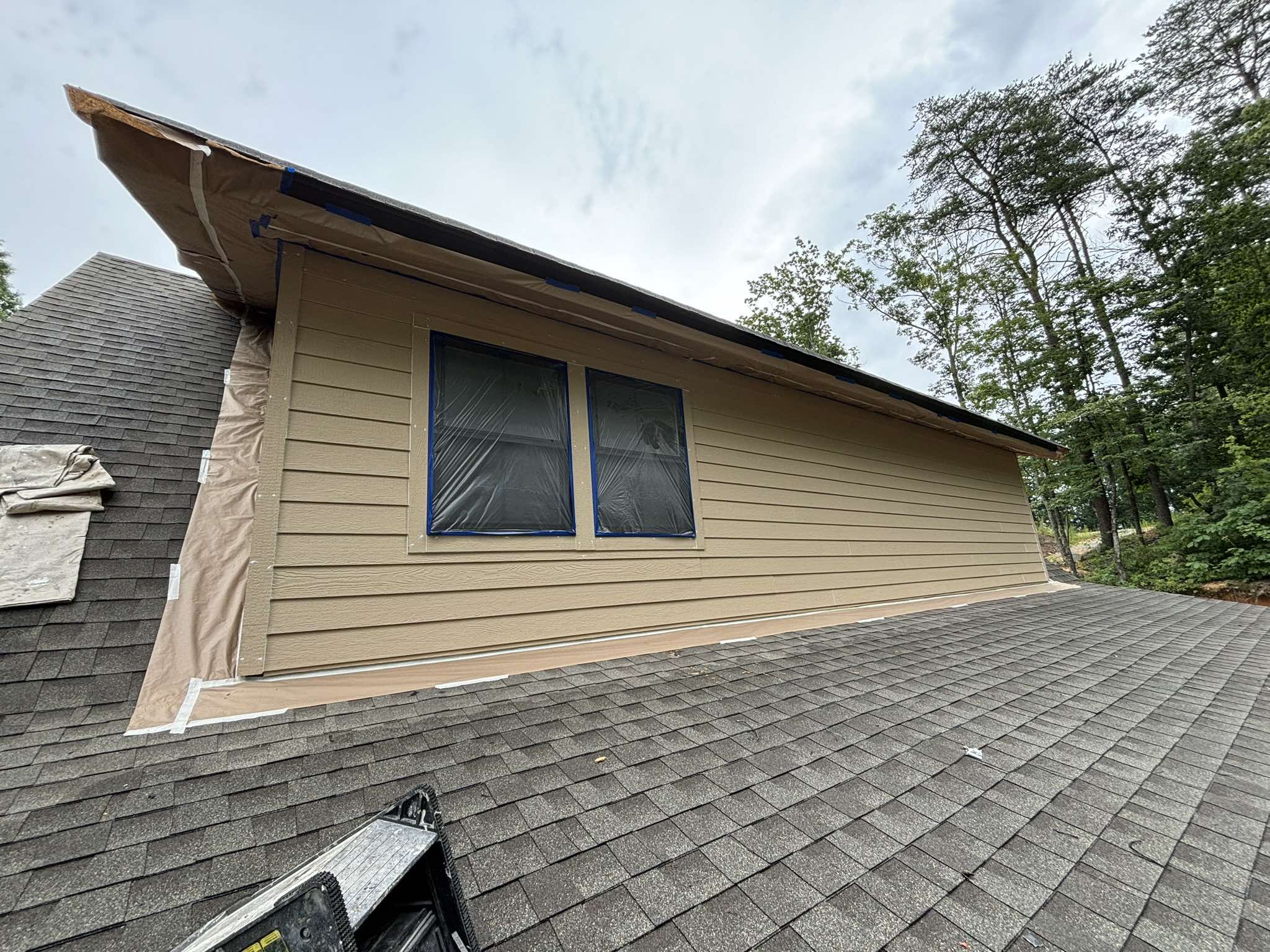 Upper garage siding and windows protected during exterior preparation above the roofline